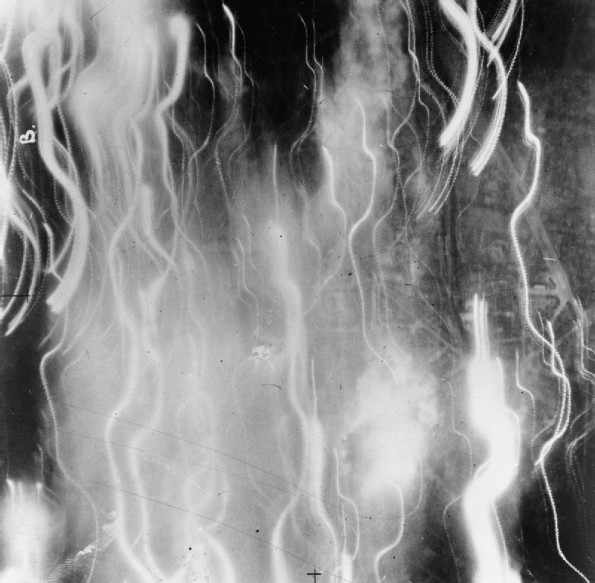 Vertical aerial photograph taken over the centre of Dusseldorf at 11 pm on 10 September 1942, at the height of the major night raid by 479 aircraft of Bomber Command. Most of the area photographed is covered with widespread incendiary fires, from which flame and smoke are rising to obscure the target.
